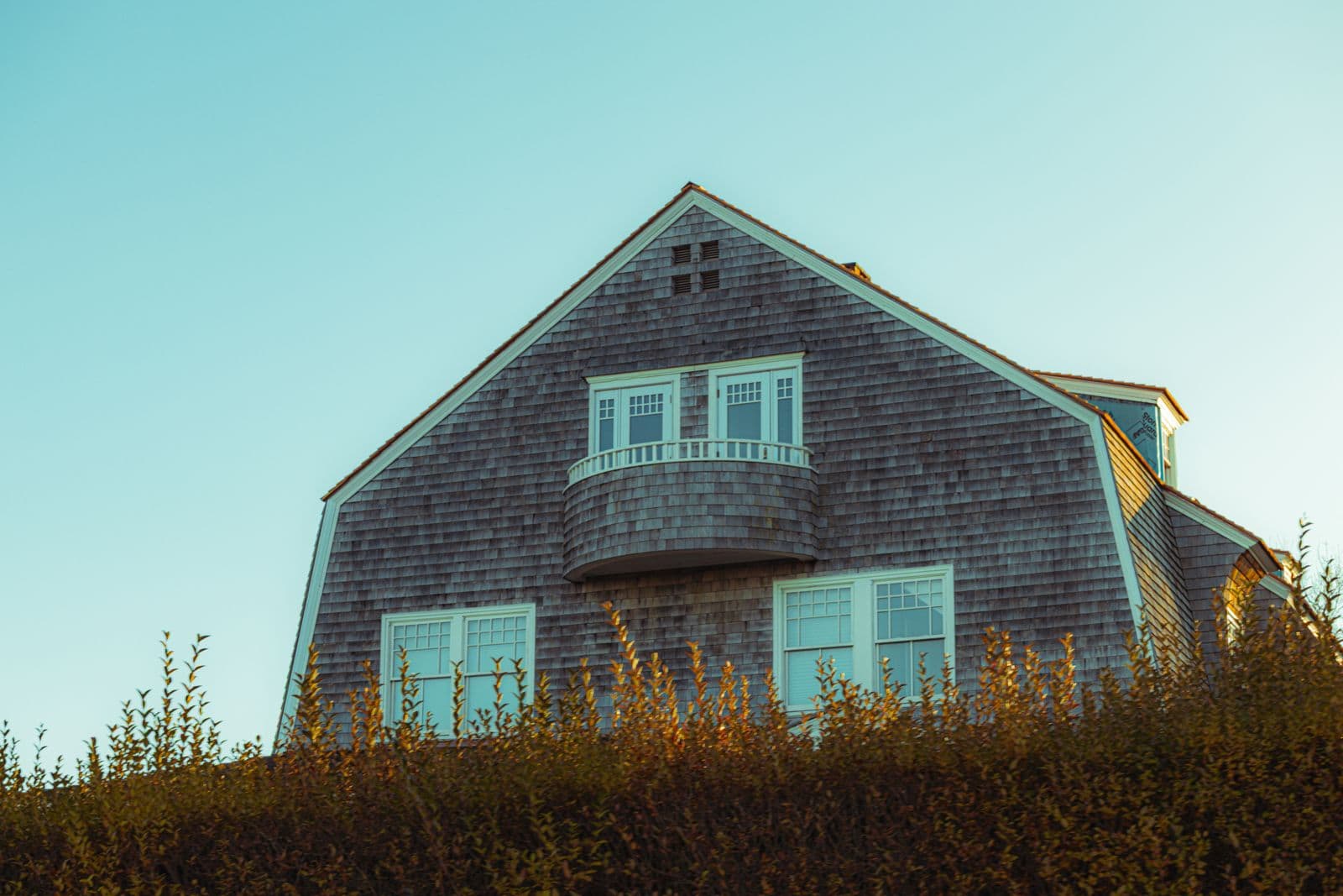 House with weathered cedar shingle siding and a balcony
