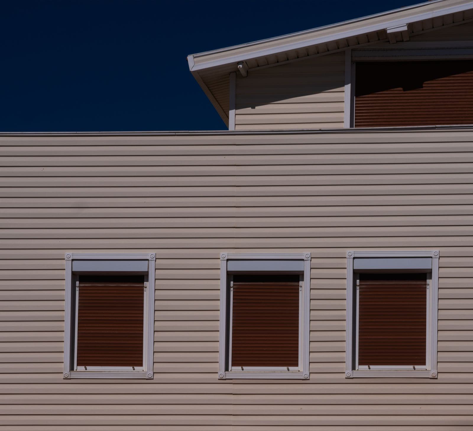 Beige horizontal cladding with shuttered windows